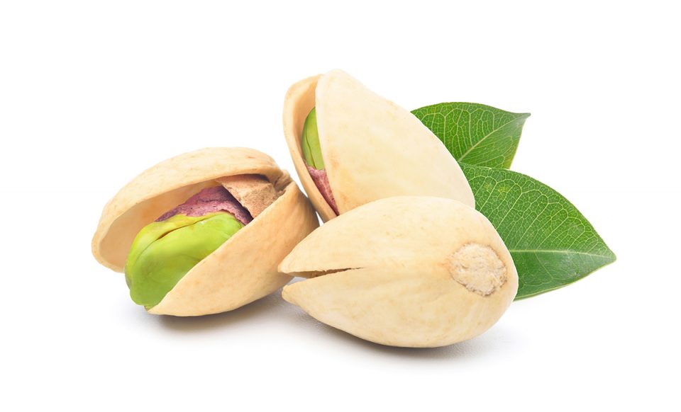 pistachio-nuts-with-green-leaves-isolated-white-background